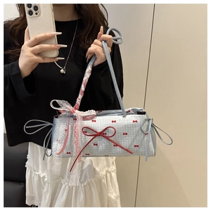Dettaglio borsa azzurra a pois con fiocchi rossi e nastro in pizzo decorativo