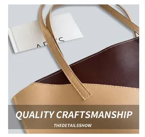 Detail of burgundy and beige tote bag featuring reinforced stitching and leather texture