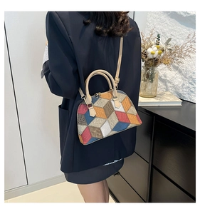 Détail d'un sac à main géométrique color-block porté par un mannequin en extérieur