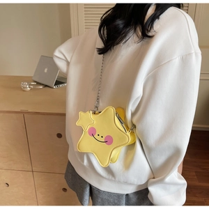 Macro shot of a star-shaped yellow leather crossbody bag featuring a playful smiley face