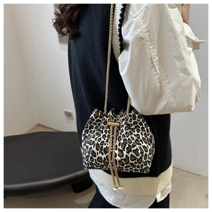 Detalle del bolso saco de leopardo con cadena dorada y cordón con adornos de perlas
