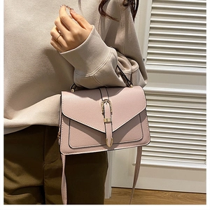 Pink faux leather shoulder bag with gold clasp and textured finish shown on a model