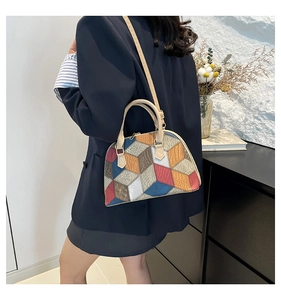 Vue détaillée d'un sac coquille patchwork multicolore porté avec un tailleur bleu