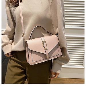 Detail view of pink lychee textured leather small square bag with golden buckle