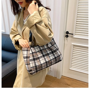 Close-up of checkered tweed tote bag with metal ring and leather shoulder strap