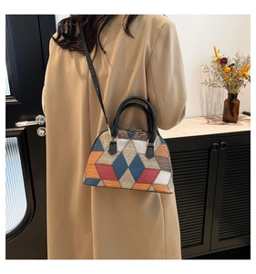 Détail du sac coquille en patchwork bicolore avec texture cuir et garnitures dorées