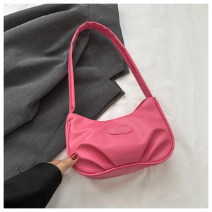 Détail d'un sac hobo plissé en PU rose avec une plaque décorative en métal fashion