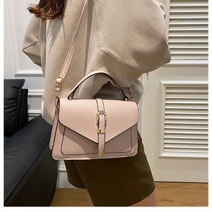 Close-up of pink lychee pattern leather handbag with gold buckle shown on model