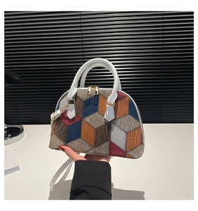 Détail du motif géométrique tricolore sur un sac coquillage avec fermetures éclair dorées
