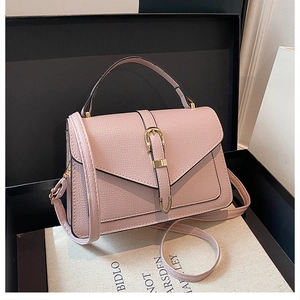 Detailed macro view of pink litchi texture leather handbag with gold metal buckle