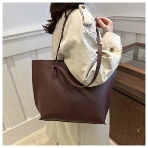 Detail of a large dark brown leather tote bag with geometric diagonal stitching accents