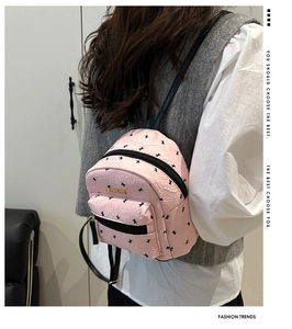 Close-up of pink mini backpack with rabbit prints and gold Fashion metal logo