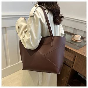 Detail of dark brown tote bag featuring geometric stitching and high-capacity structure