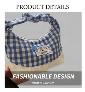 Detail of blue gingham bucket bag with white lace trim and decorative dog patch