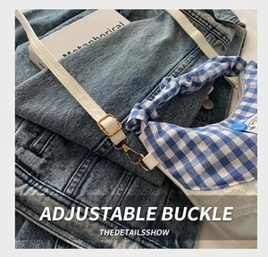 Detail of blue and white checkered bag with adjustable gold buckle and lace trim