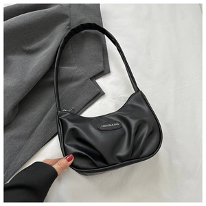 Détail du sac hobo plissé noir avec un emblème métallique FASHION & BAG élégant
