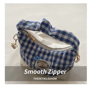 Detail of blue and white gingham bag showing gold zipper, handmade label and scrunchie handle