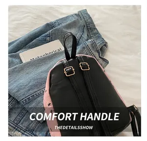Detail of mini backpack featuring black faux leather back and adjustable straps