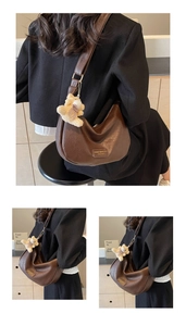 Detail view of brown PU leather hobo bag with teddy bear charm and metal logo plaque