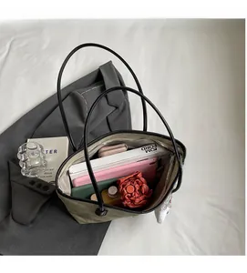 Detailed interior of olive green tote bag showing spacious storage and secure zip closure