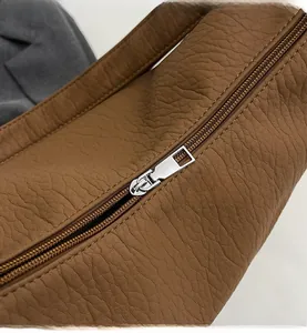 Close-up of smooth silver metal zipper on vintage brown leather large hobo bag