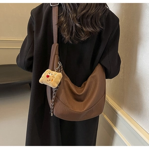 Brown lychee grain PU crescent bag with a cute plush toast pendant detail