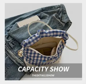 Internal capacity of blue and white gingham crossbody bag with lace trim and slim strap
