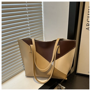 Detail of color-block geometric tote bag with brown and beige faux leather stitching