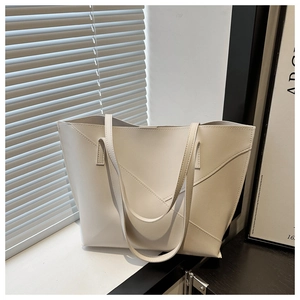 Detail of minimalist tote bag showing geometric stitching and off-white PU leather texture