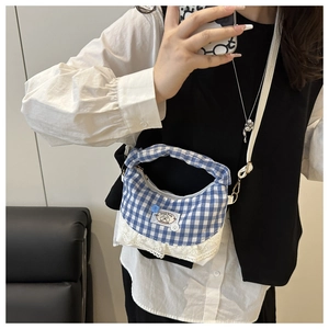 Detail of blue and white checkered crossbody bag featuring lace trim and cartoon dog patch