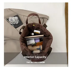 Intérieur spacieux du cabas matelassé marron avec ordinateur, parapluie et accessoires