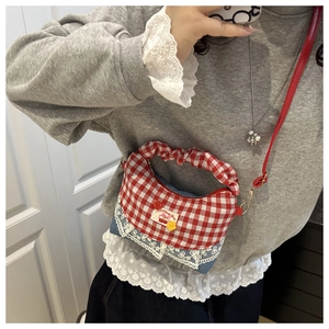 Detail of red gingham handbag with blue denim base and white lace trim decoration
