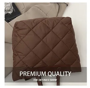 Détail du motif matelassé en losange sur un grand sac cabas marron en nylon chic