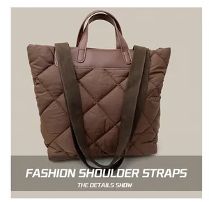 Détail de la bandoulière large et du motif matelassé sur le sac fourre-tout marron