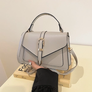 Minimalist grey lychee leather handbag with gold buckle and top handle for commuting