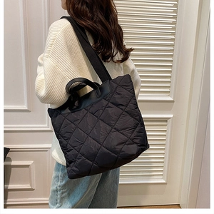 Gros plan sur la texture matelassée du sac fourre-tout noir avec détails de couture fins