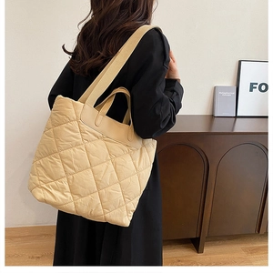 Détail du grand sac cabas matelassé beige avec une bandoulière large et confortable