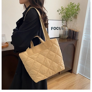 Détail du sac cabas matelassé beige avec motif en losanges et large bandoulière