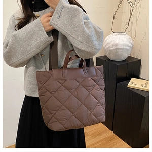 Gros plan d'un grand sac fourre-tout matelassé marron avec surpiqûres en losanges et cuir