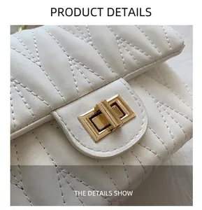Close-up of white quilted handbag with a rectangular gold twist lock and fine stitching