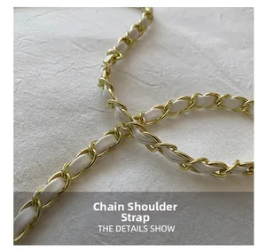 Close-up of woven gold metal chain and white leather shoulder strap for crossbody bag
