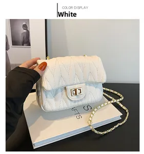 Close-up of white quilted shoulder bag featuring gold twist lock and chain strap