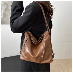 Close-up of the vintage brown leather hobo bag showing silver zipper details and soft texture