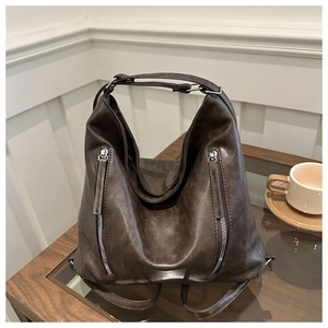 Detail of vintage brown tote bag with textured leather and dual vertical silver zippers