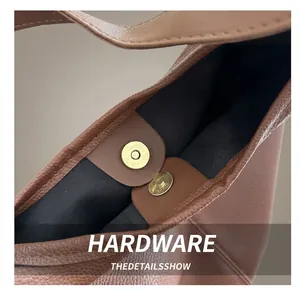 Detailed view of brown lychee grain leather tote with a magnetic snap closure