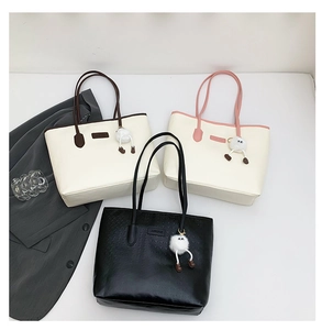 Three large houndstooth tote bags with cute puff ball charms in various colors
