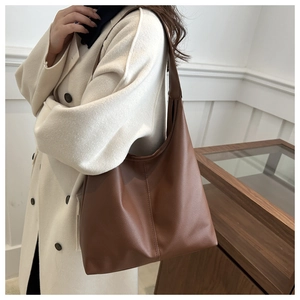 Detail of brown lychee grain leather tote bag with vertical stitching for daily commute