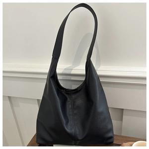 Macro detail of black hobo bag with pebble leather texture and vertical stitching