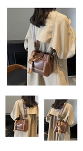 Detalle de bolso cubo vintage marrón con correa tejida ancha y colgante de conejo de peluche
