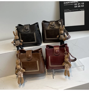 Grupo de cuatro bolsos de cubo vintage en negro, marrón y rojo con colgantes de conejo